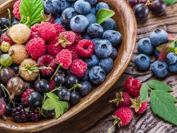 Ripe berries in the wooden bowl. — Stock Photo, Image