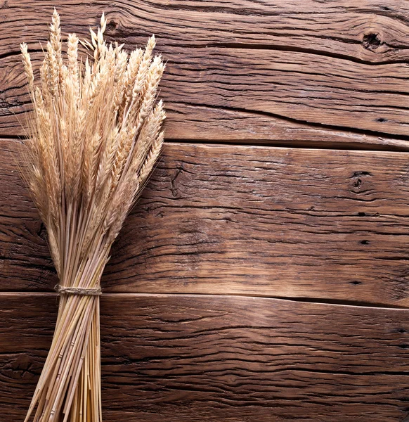 Ears of wheat on old wooden table. — Stock Photo, Image