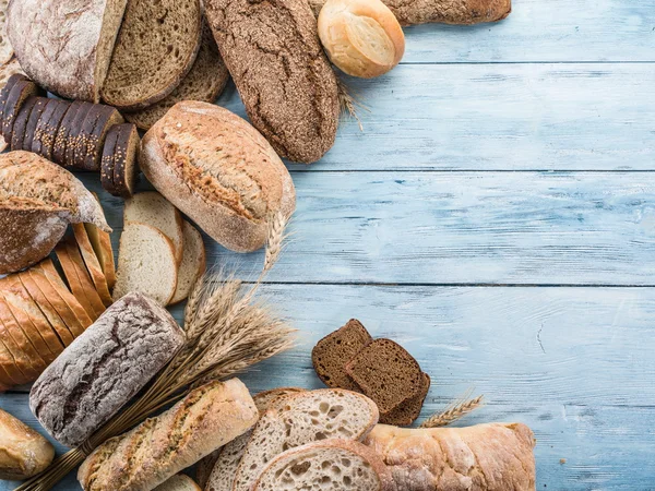 Het brood en een tarwe op de houten bureau. — Stockfoto