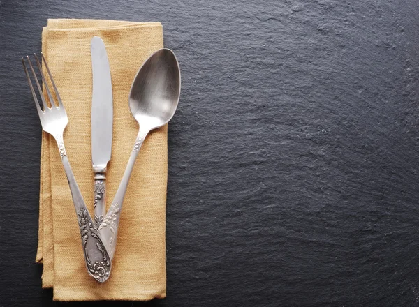 Silver cutlery on a dark grey background. — Stock Photo, Image