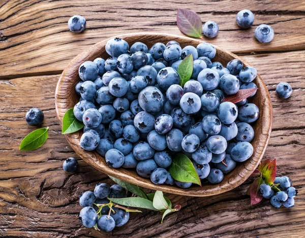 Reife Blaubeeren in der Schüssel auf dem Holztisch. — Stockfoto