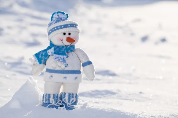 Pequeno boneco de neve com nariz de cenoura na neve . — Fotografia de Stock