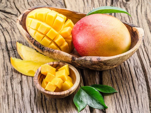 Mango fruit and mango cubes on the wooden table. — Stock Photo, Image