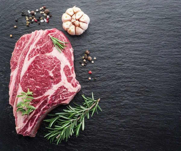 Rib eye steak s kořením na černém pozadí. — Stock fotografie