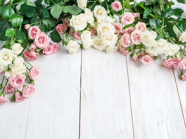 Нежные свежие розы на белом деревянном фоне . — стоковое фото