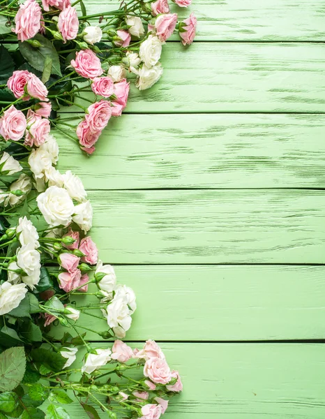 Delicadas rosas frescas sobre el fondo verde de madera . —  Fotos de Stock