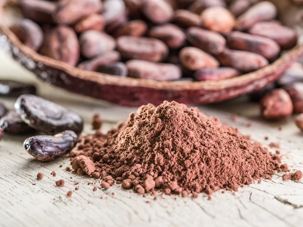 Cocao em pó e feijão cocao na mesa de madeira . — Fotografia de Stock