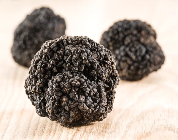 Trufas negras en la vieja mesa de madera. — Foto de Stock