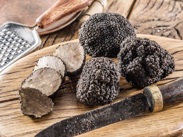 Trufas pretas na velha mesa de madeira. — Fotografia de Stock