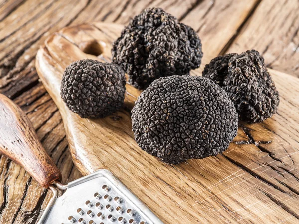 Black truffles on the old wooden table. — Stock Photo, Image