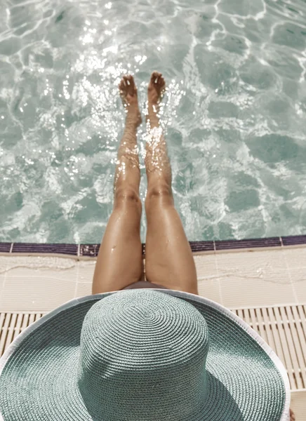 Kvinna sitter på kanten av poolen. — Stockfoto