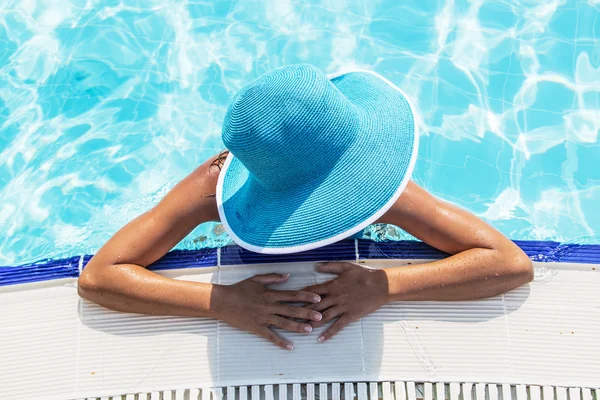 Vrouw in zon hoed in het zwembad. Bovenaanzicht. — Stockfoto