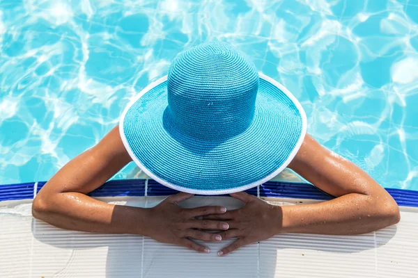Žena v klobouku slunce v bazénu. — Stock fotografie