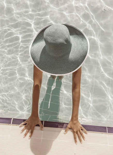 Kvinna i solhatt i poolen. Ovanifrån. — Stockfoto