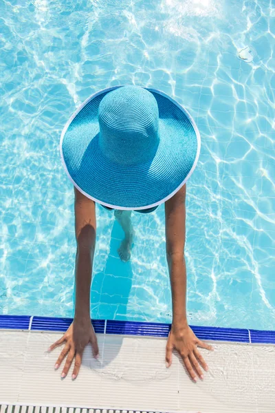 Woman in sun hat in the swimming pool. Top view.