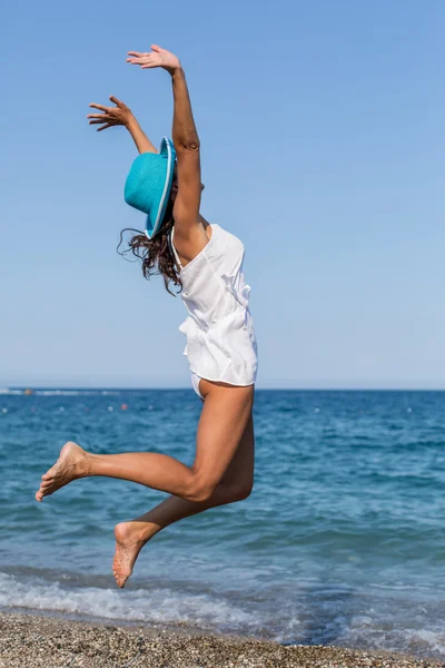 Vrouw springen op het strand. — Stockfoto