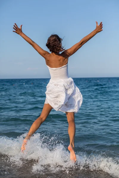 Mujer saltando en la playa. — Foto de Stock