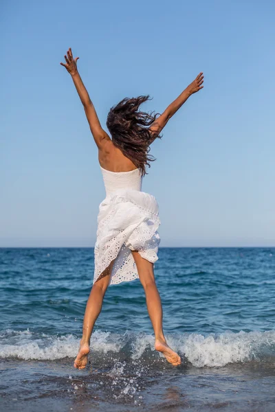 Mujer saltando en la playa del mar . —  Fotos de Stock