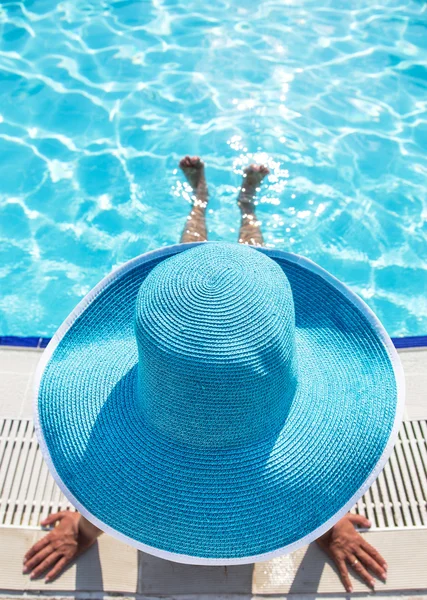 Mulher sentada na beira da piscina . — Fotografia de Stock