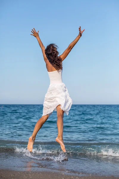Kobieta skacząca po plaży. — Zdjęcie stockowe