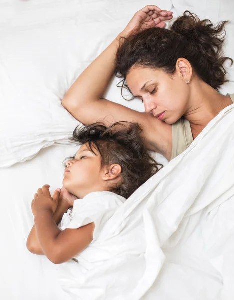 Uyuyan çocuk kız ve annesi yatakta. — Stok fotoğraf