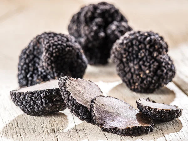 Black truffles on the old wooden table. — Stock Photo, Image