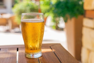 Ahşap masa üzerinde light bira bardak.