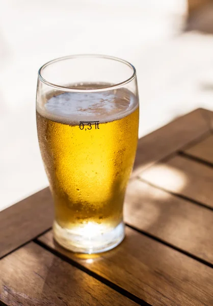 Verre de bière légère sur la table en bois . — Photo