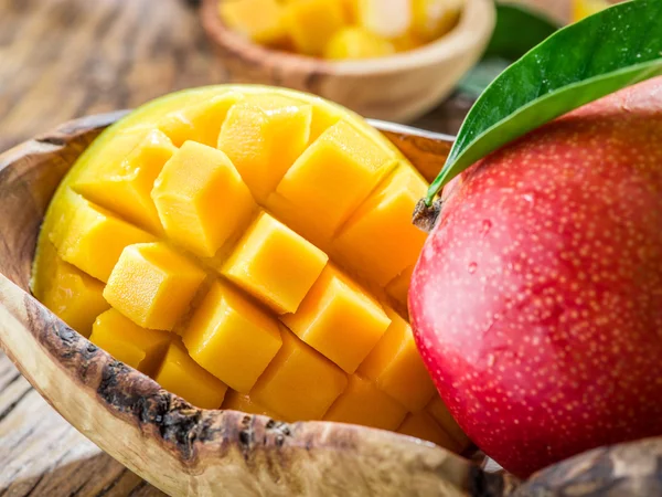 Mangofrüchte und Mangowürfel auf dem Holztisch. — Stockfoto