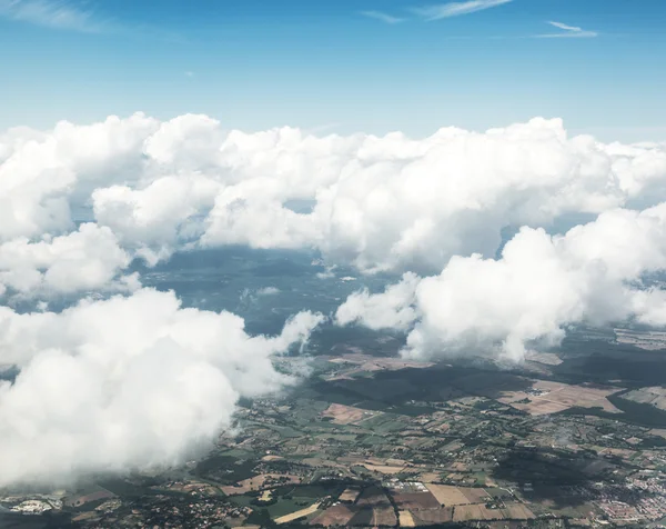 Letecký pohled na mraky a krajinu pod nimi. — Stock fotografie
