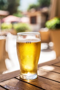 Ahşap masa üzerinde light bira bardak.