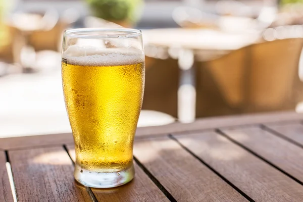 Copo de cerveja leve na mesa de madeira . — Fotografia de Stock