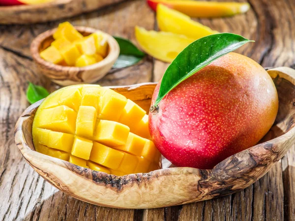Φρούτα μάνγκο και μάνγκο κύβους στο ξύλινο τραπέζι. — Φωτογραφία Αρχείου