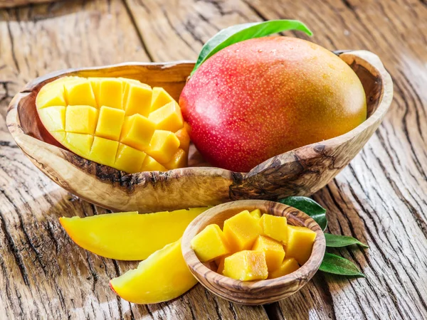 Cubos de mango y fruta de mango en la mesa de madera . — Foto de Stock