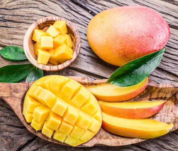 Mango ovoce a mango kostky na dřevěný stůl. — Stock fotografie