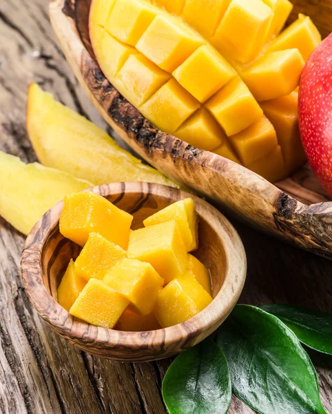 Mango fruit and mango cubes on the wooden table. — Stock Photo, Image