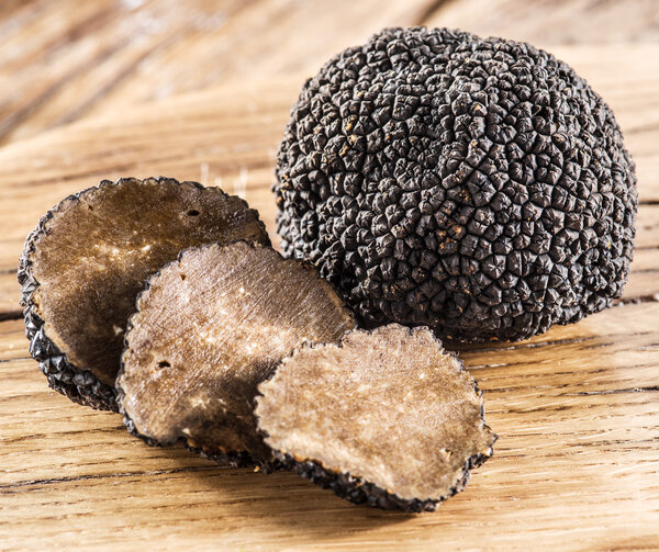 Black truffles on the old wooden table.