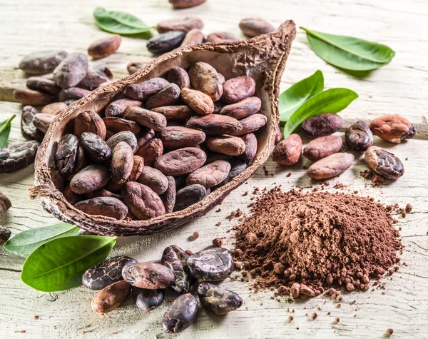 Cocao em pó e feijão cocao na mesa de madeira . — Fotografia de Stock