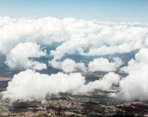 Flygfoto över moln och landskap under dem. — Stockfoto