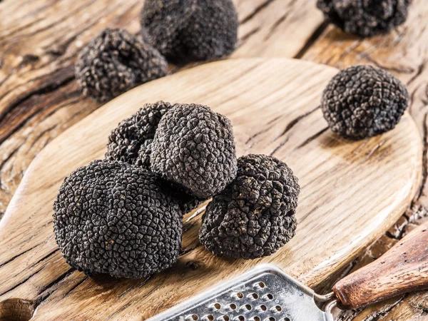 Trufas negras en la vieja mesa de madera. — Foto de Stock