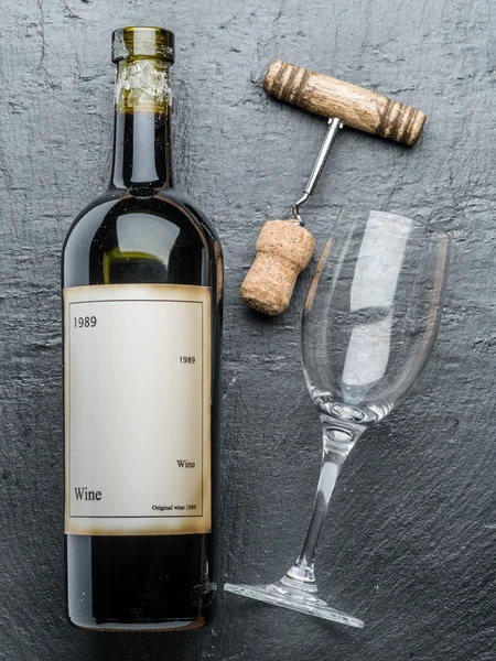Botella de vino, copa de vino y sacacorchos en la pizarra de grafito . — Foto de Stock