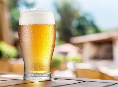 Ahşap masa üzerinde light bira bardak.