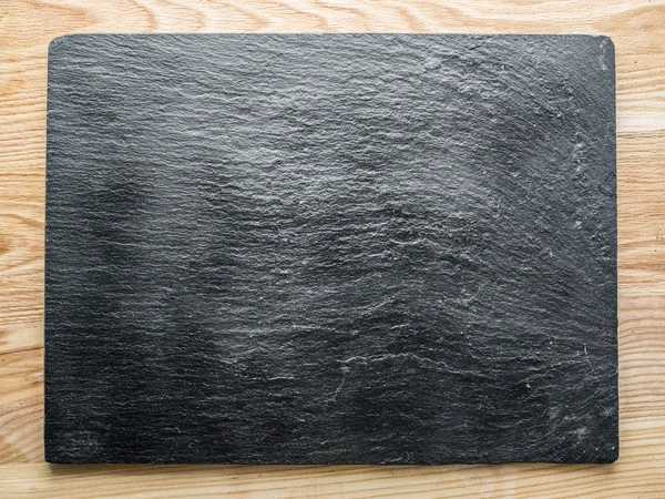 Graphite plank on the wooden table. — Stock Photo, Image