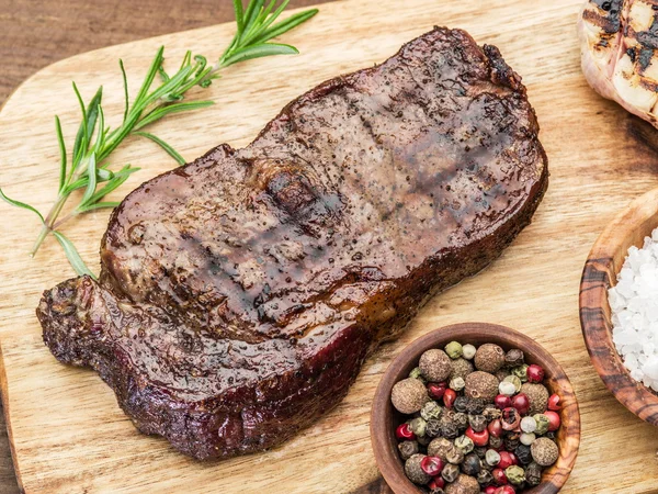 Bife Ribeye com especiarias na bandeja de madeira . — Fotografia de Stock