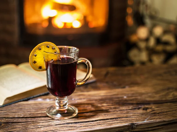 Vino rimuginato caldo e un libro sul tavolo di legno . — Foto Stock