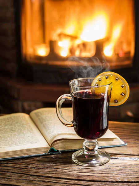 Ζεστό mulled κρασί και ένα βιβλίο πάνω στο ξύλινο τραπέζι. — Φωτογραφία Αρχείου