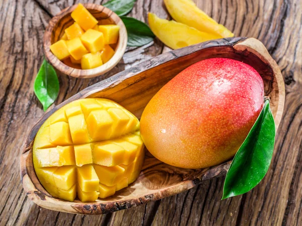 Mangofrüchte und Mangowürfel auf dem Holztisch. — Stockfoto
