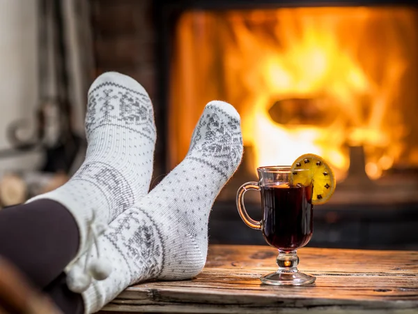 Aquecimento e relaxamento perto da lareira com uma xícara de vinho quente . — Fotografia de Stock