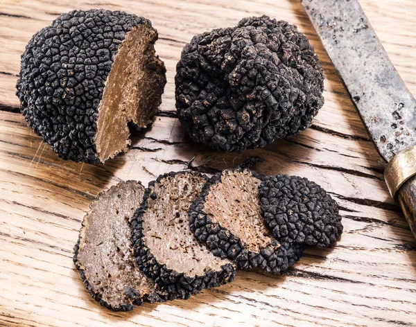 Black truffles on the old wooden table. — Stock Photo, Image