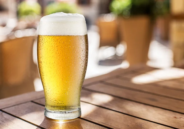 Copo de cerveja leve na mesa de madeira . — Fotografia de Stock